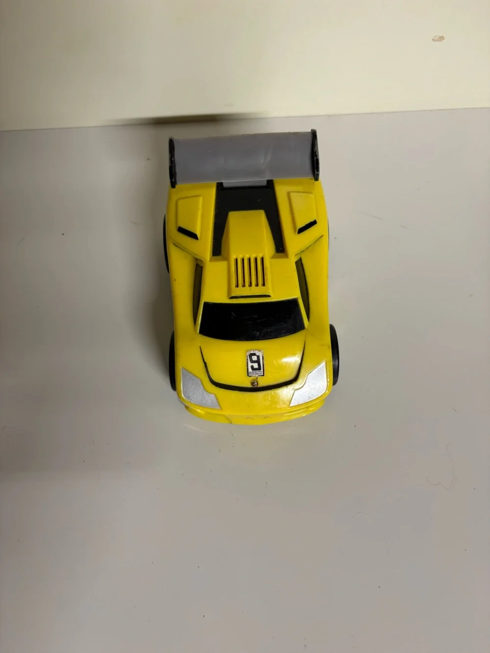 2005 Fisher-Price Shake 'n Go! yellow exotic race car featuring a prominent numb